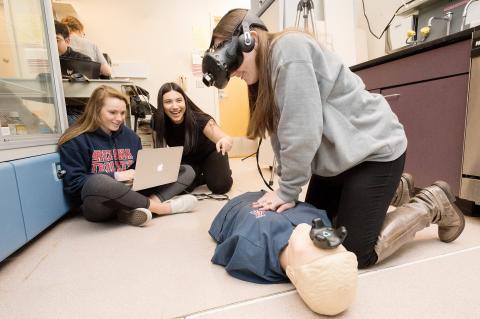 UA engineering students fine-tune their virtual reality system for CPR training after hours on the floor of a lab at the Sarver Heart Center.