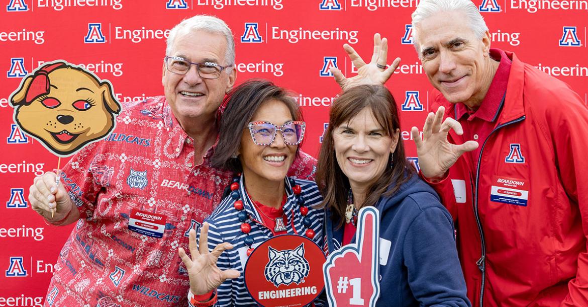 four people in front of a photo backdrop