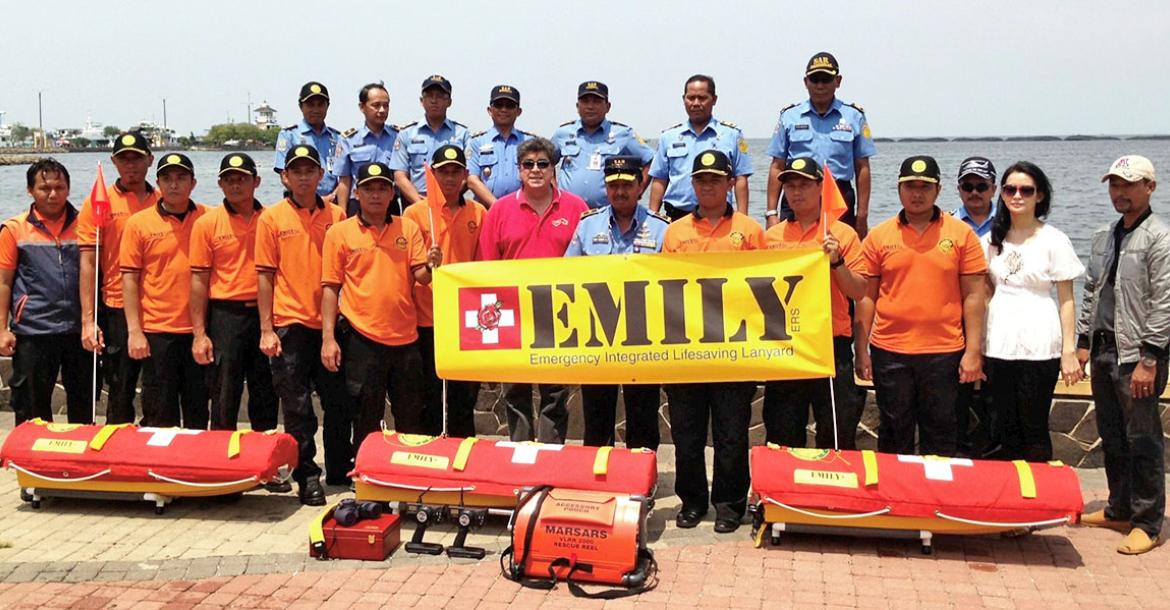 a large group of people pose near water with rescue equipment