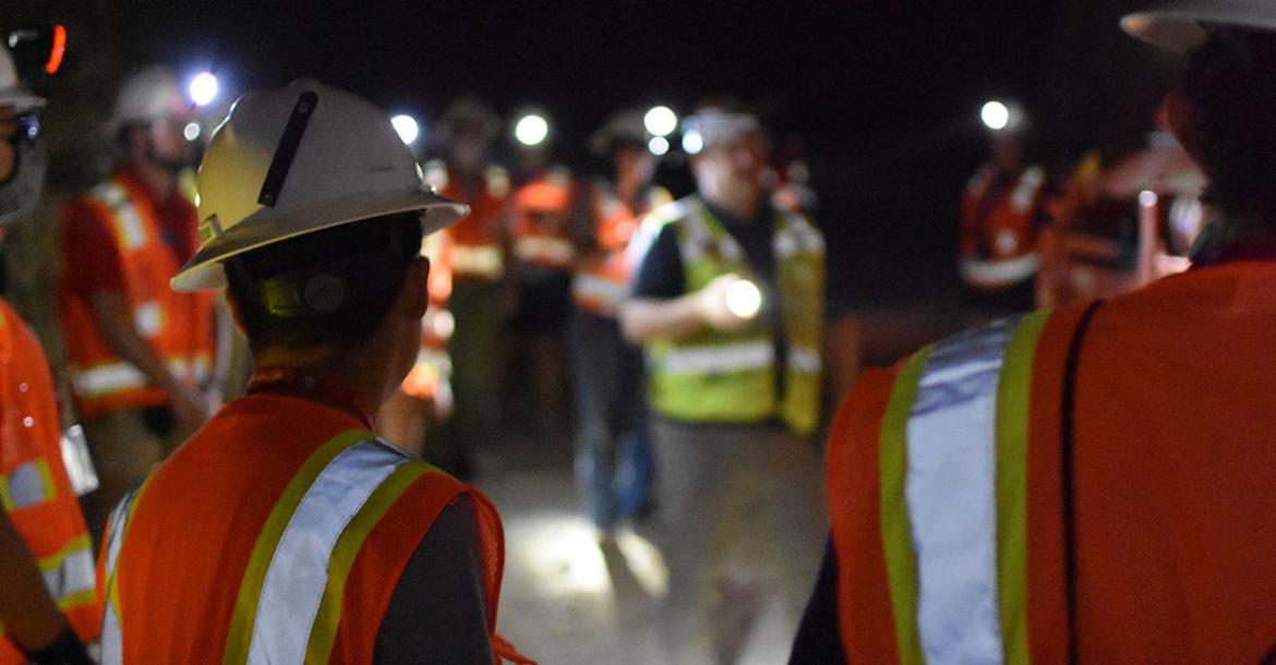 a group of students tour a dark mine