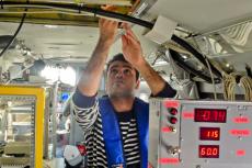 Doctoral student Hossein Dadashazar collects cloud water samples aboard the Navy Twin Otter.