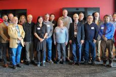 the large group of awardees stands together indoors