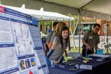 A group of students at an outdoor expo table