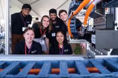 6 students pose with a manufacturing device