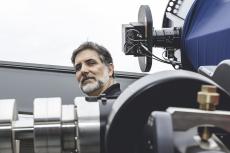 Roberto Furfaro standing behind a telescope