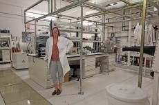 Erin Ratcliff in her lab, wearing a lab coat.