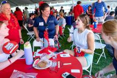 a group of students and faculty at an event table