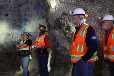 5 people wearing hard hats stand inside a mind