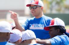 Ricardo Valerdi addresses a group of children in baseball caps outdoors